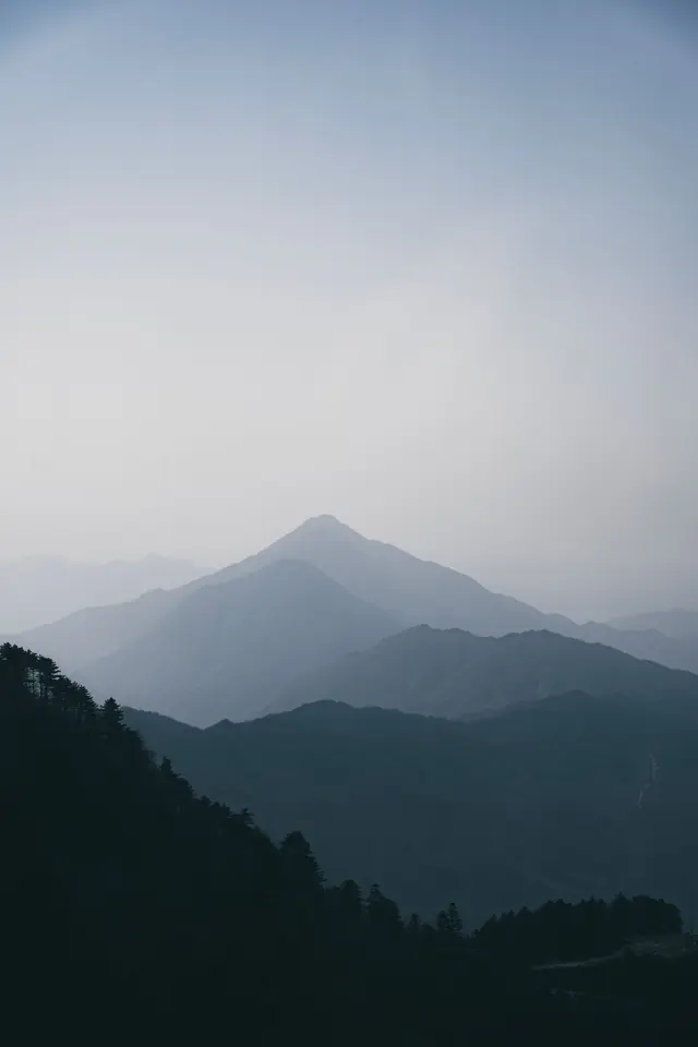 Layered misty mountains on a calm morning